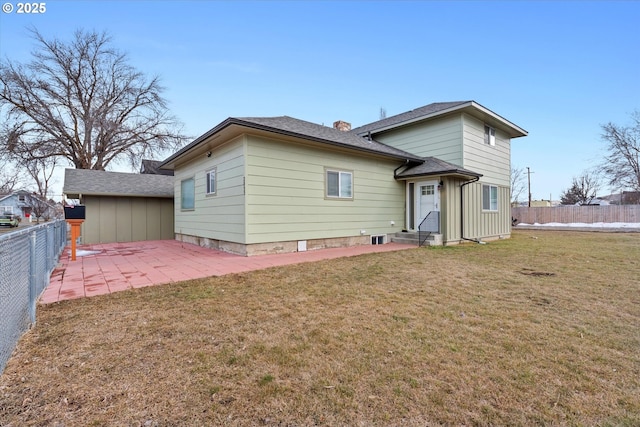 rear view of house with entry steps, a fenced backyard, a chimney, a yard, and a patio area