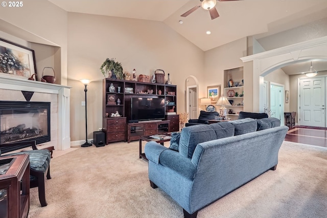 1114 S 6th Way, Ridgefield, WA 98642 - living area featuring arched walkways, ceiling fan, carpet floors, high vaulted ceiling, and a tile fireplace