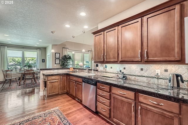 1114 S 6th Way, Ridgefield, WA 98642 - kitchen featuring stainless steel dishwasher, a sink, a peninsula, light wood-style flooring, and a textured ceiling