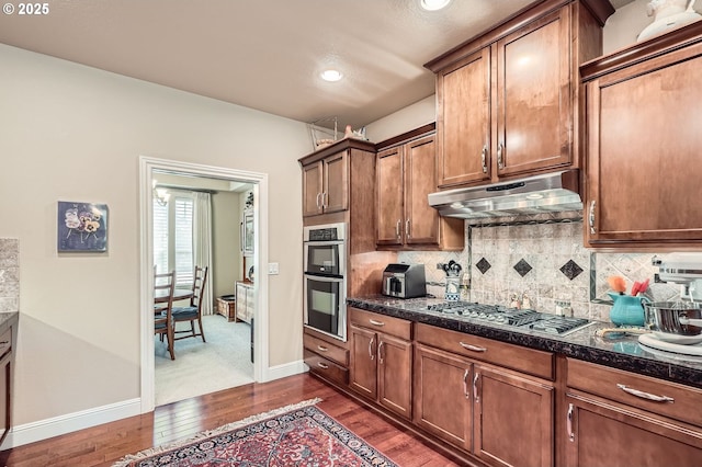 1114 S 6th Way, Ridgefield, WA 98642 - kitchen featuring under cabinet range hood, appliances with stainless steel finishes, dark wood finished floors, backsplash, and recessed lighting