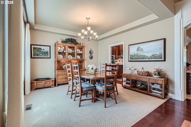 1114 S 6th Way, Ridgefield, WA 98642 - dining area featuring a tray ceiling, a chandelier, wood-type flooring, and baseboards