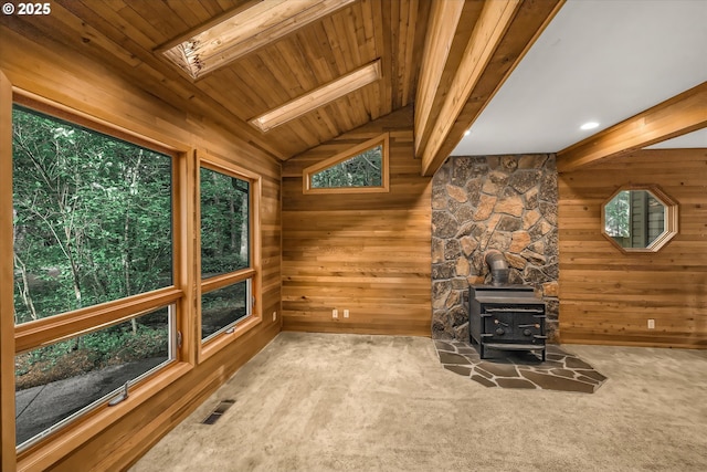65277 E Sandy River Ln, Rhododendron, OR 97049 - unfurnished living room featuring a wood stove, wooden walls, carpet flooring, a skylight, and wooden ceiling