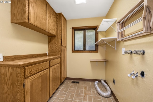 65277 E Sandy River Ln, Rhododendron, OR 97049 - laundry room featuring cabinet space, baseboards, electric dryer hookup, and brick patterned floors