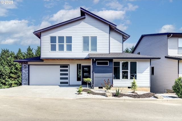 view of front facade with a garage, driveway, and a shingled roof