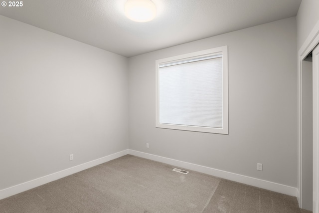 spare room with a textured ceiling and carpet