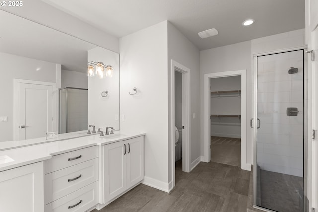 bathroom with vanity, hardwood / wood-style flooring, and a shower with shower door