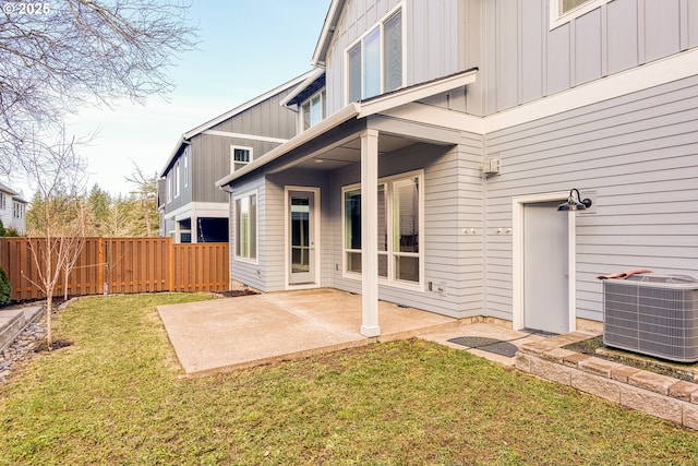 rear view of house with central AC unit, a yard, and a patio