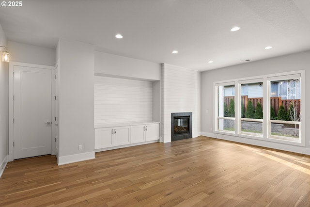 unfurnished living room with a fireplace and light hardwood / wood-style floors