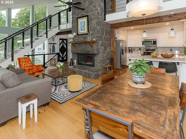 1339 NW 7th Ave, Camas, WA 98607 - living area with light wood-type flooring, ceiling fan, a towering ceiling, stairway, and a fireplace