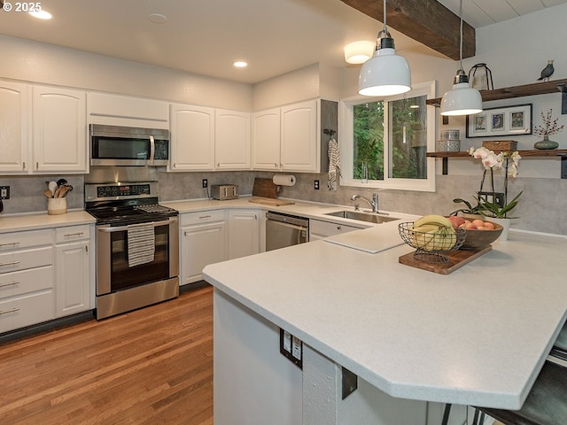 1339 NW 7th Ave, Camas, WA 98607 - kitchen featuring appliances with stainless steel finishes, a sink, a peninsula, light wood finished floors, and backsplash