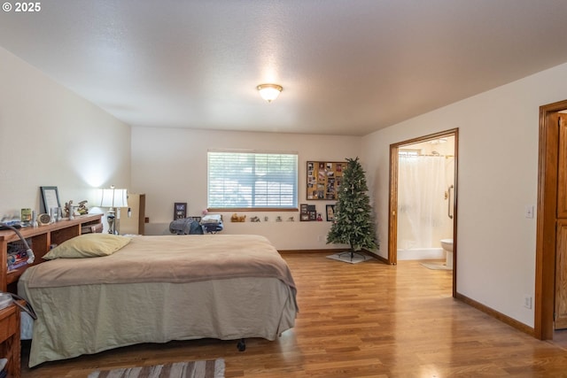 128 NW Woodrose Ct, Roseburg, OR 97471 - bedroom with light wood-style floors, ensuite bathroom, and baseboards