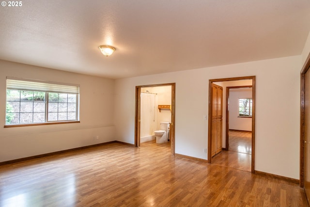 128 NW Woodrose Ct, Roseburg, OR 97471 - unfurnished bedroom featuring multiple windows, light wood finished floors, and ensuite bath
