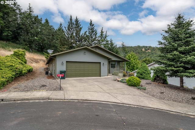 128 NW Woodrose Ct, Roseburg, OR 97471 - view of front of house featuring concrete driveway, a garage, and a porch