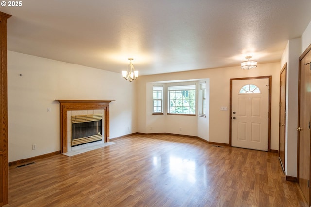 128 NW Woodrose Ct, Roseburg, OR 97471 - unfurnished living room with a chandelier, wood finished floors, and a fireplace