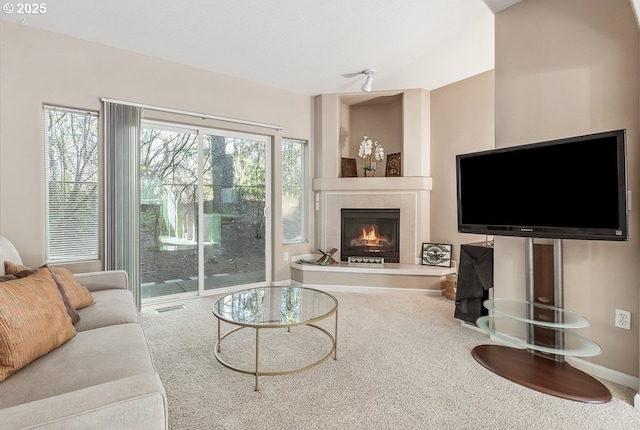 living room featuring a tiled fireplace and carpet floors