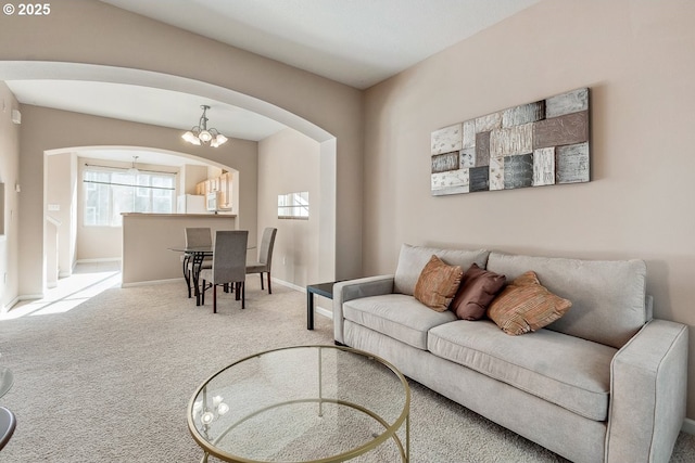 carpeted living room featuring a chandelier