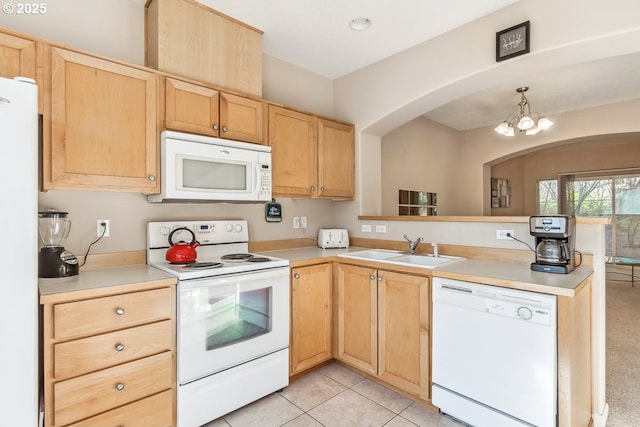 kitchen with pendant lighting, sink, white appliances, and light brown cabinets