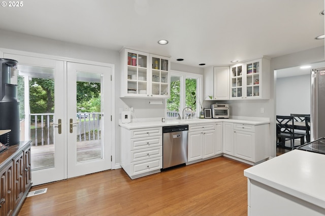 4433 SW 201st Ave, Beaverton, OR 97078 - kitchen with stainless steel dishwasher, recessed lighting, light wood-style floors, white cabinets, and glass insert cabinets