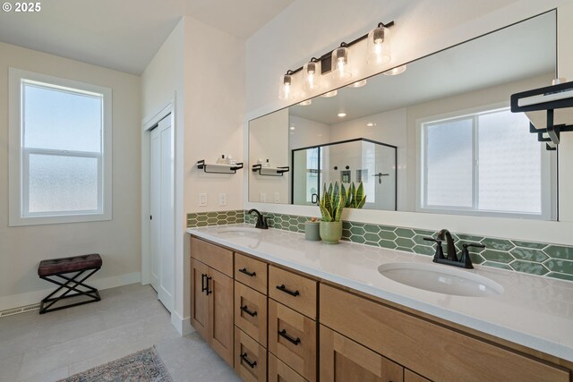 bathroom featuring plenty of natural light, a sink, decorative backsplash, and a stall shower