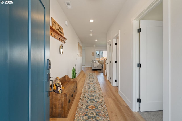 hallway with recessed lighting, visible vents, and light wood-style floors