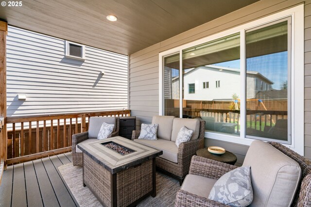deck featuring an outdoor living space with a fire pit