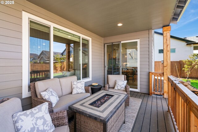 wooden deck featuring fence and an outdoor living space with a fire pit