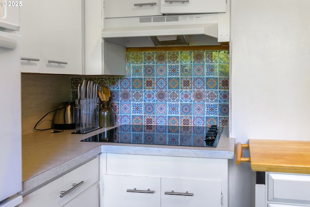 560 N 10th St, Coos Bay, OR 97420 - kitchen with under cabinet range hood, white cabinets, black electric cooktop, backsplash, and light countertops