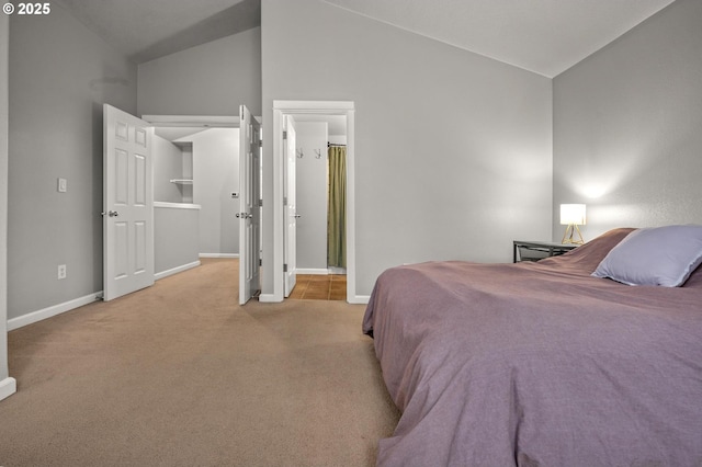 bedroom with lofted ceiling, light carpet, and baseboards