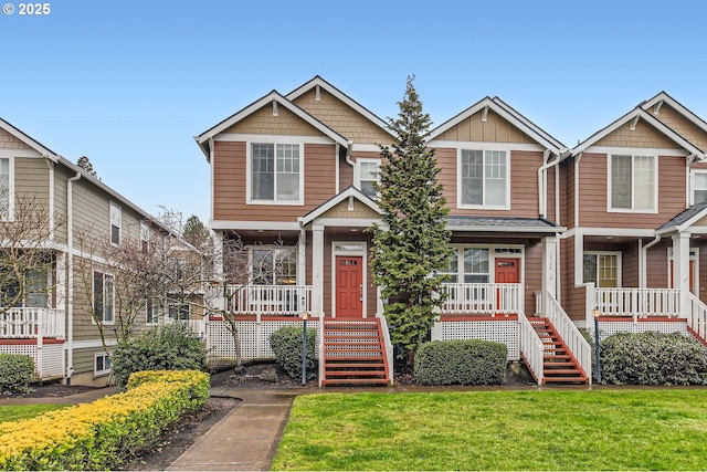 view of front of home featuring stairs, board and batten siding, and a front yard