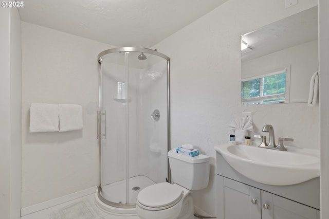 bathroom featuring baseboards, toilet, a stall shower, and vanity