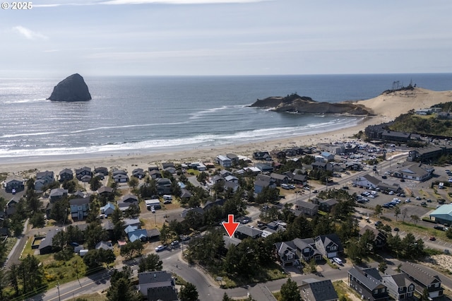 birds eye view of property with a water view and a beach view