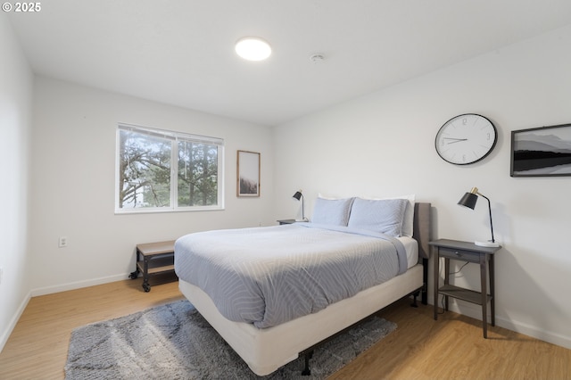 bedroom with light wood-style floors and baseboards