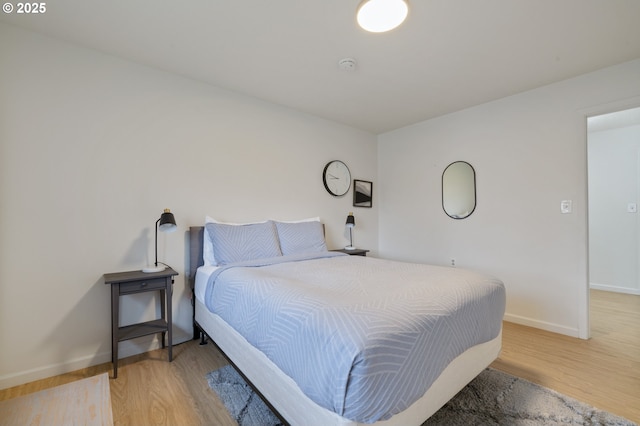 bedroom with light wood-style flooring and baseboards