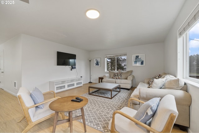 living room featuring a wealth of natural light, light wood-style flooring, and baseboards