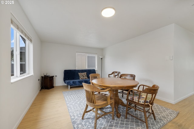 dining area featuring light wood-type flooring and baseboards