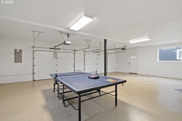 playroom with electric panel, a garage, and speckled floor