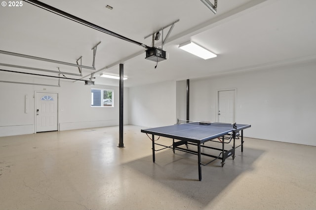 recreation room featuring speckled floor and a garage