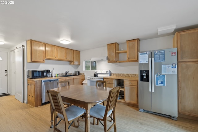 kitchen with light wood-style flooring, appliances with stainless steel finishes, light countertops, and open shelves