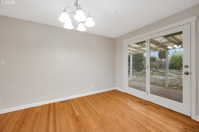 unfurnished room featuring wood-type flooring and a notable chandelier