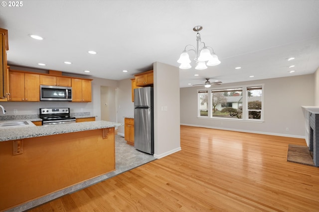 kitchen with a kitchen bar, sink, kitchen peninsula, and appliances with stainless steel finishes