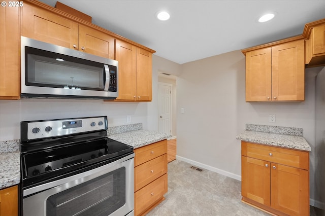 kitchen featuring stainless steel appliances and light stone counters