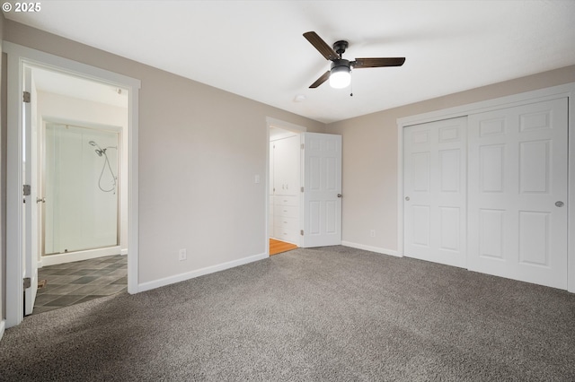 unfurnished bedroom with dark colored carpet, ceiling fan, ensuite bath, and a closet