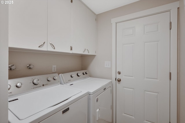 clothes washing area with cabinets and washer and dryer