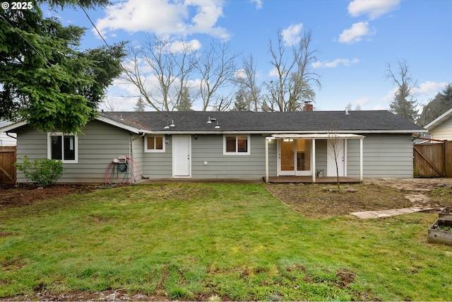 rear view of house featuring a yard