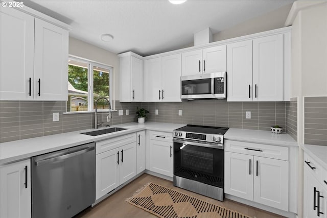 7995 SE Roslyn St, Milwaukie, OR 97222 - kitchen with appliances with stainless steel finishes, white cabinets, light countertops, and decorative backsplash