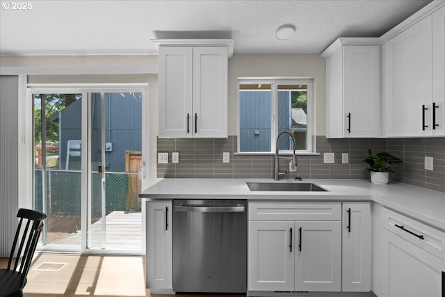 7995 SE Roslyn St, Milwaukie, OR 97222 - kitchen featuring stainless steel dishwasher, tasteful backsplash, light countertops, and white cabinetry