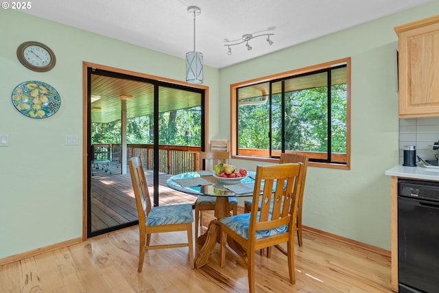 dining space with light wood-style flooring and baseboards