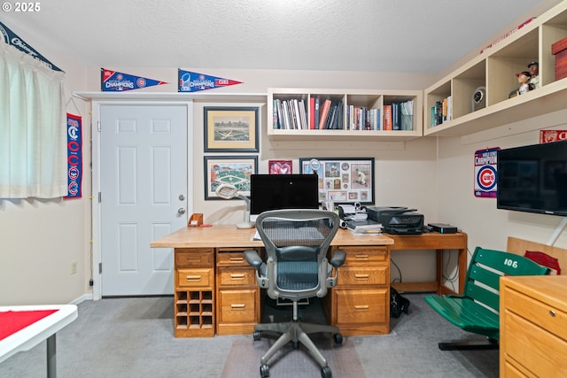 carpeted home office featuring a textured ceiling
