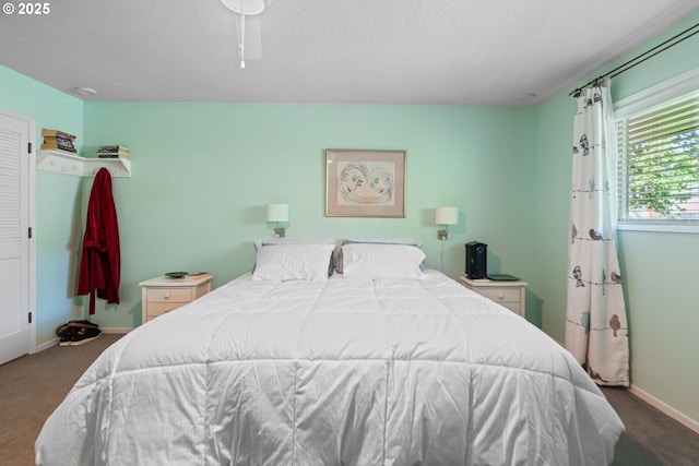carpeted bedroom with baseboards and a textured ceiling