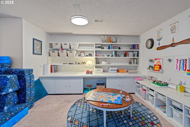 playroom with light carpet and a textured ceiling